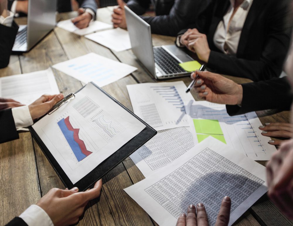 Business people analyzing documents Business people analyzing financial documents showing income, charts and graphs, teamwork concept